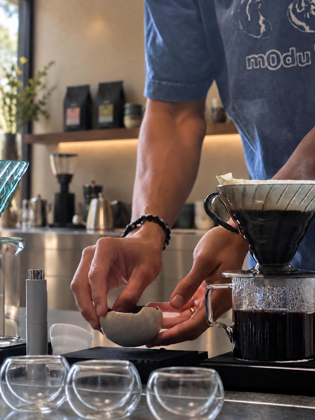 Coffee being prepared beside a V60 brewer at the pour-over bar